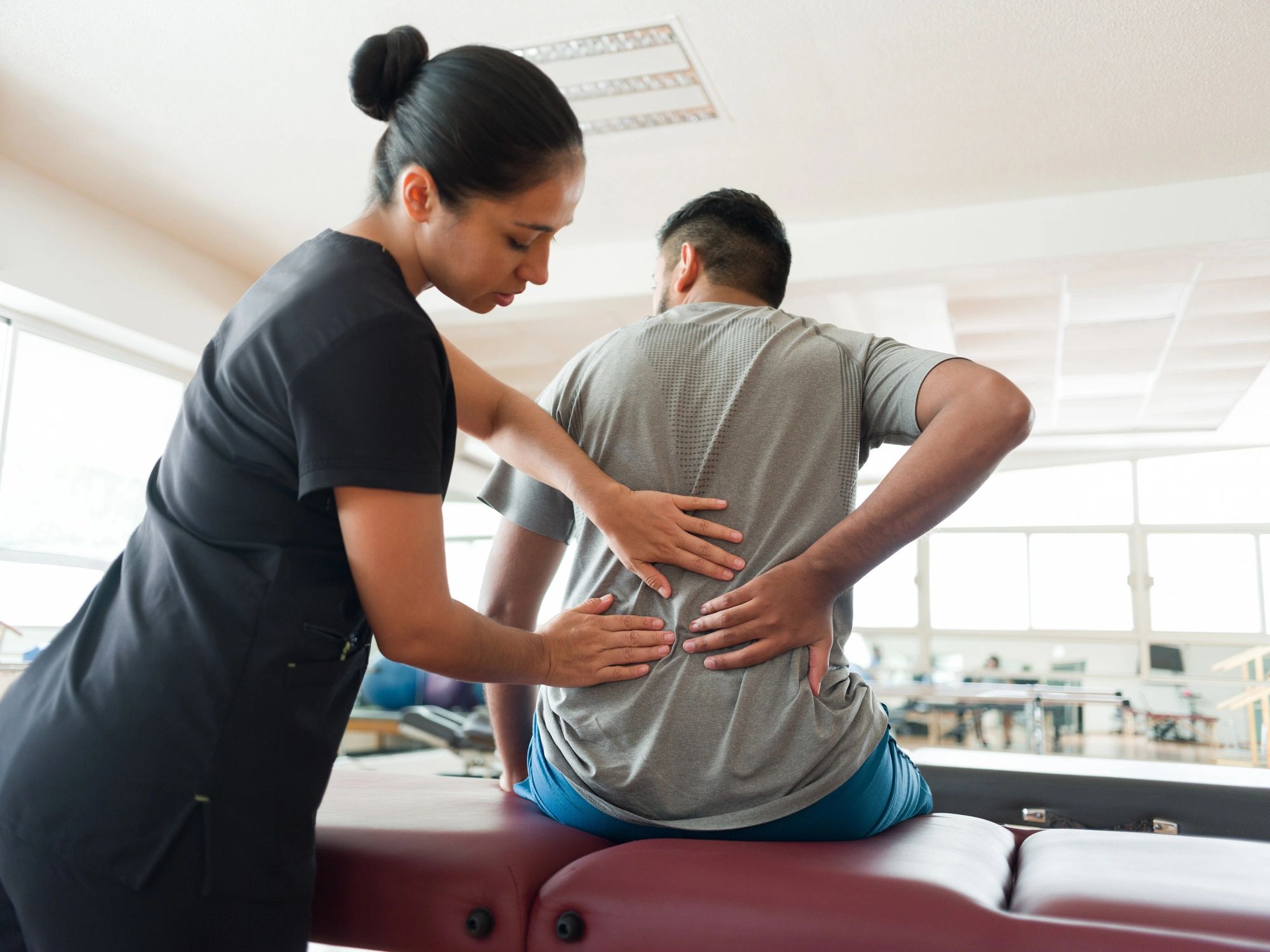 Massage therapist providing back treatment in a wellness clinic