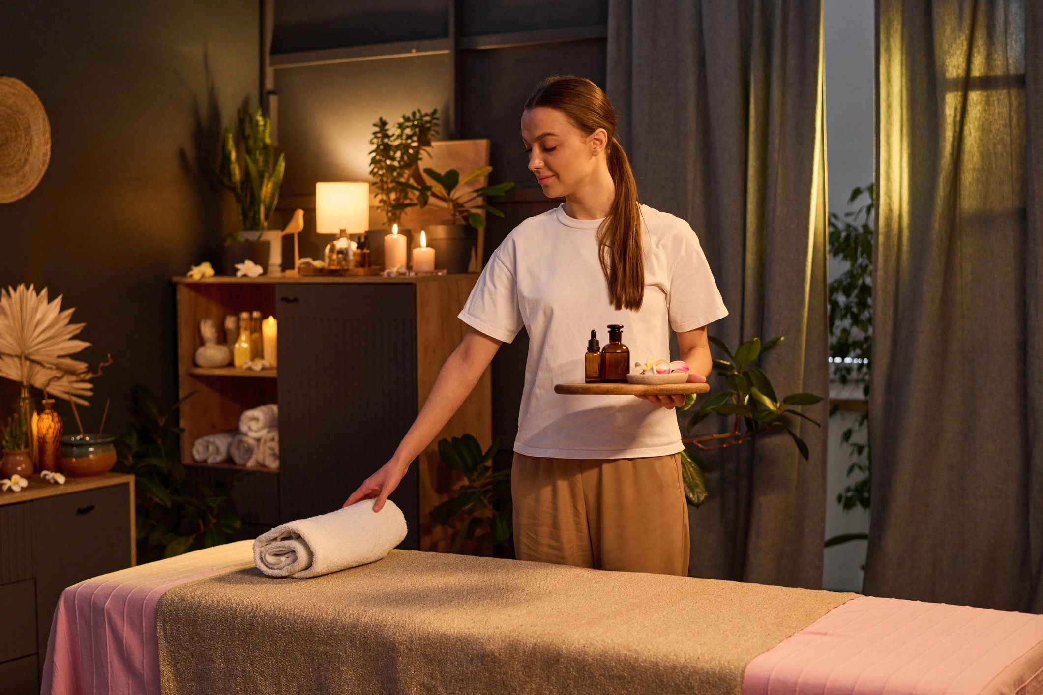 Massage therapist preparing towels and oils for a session