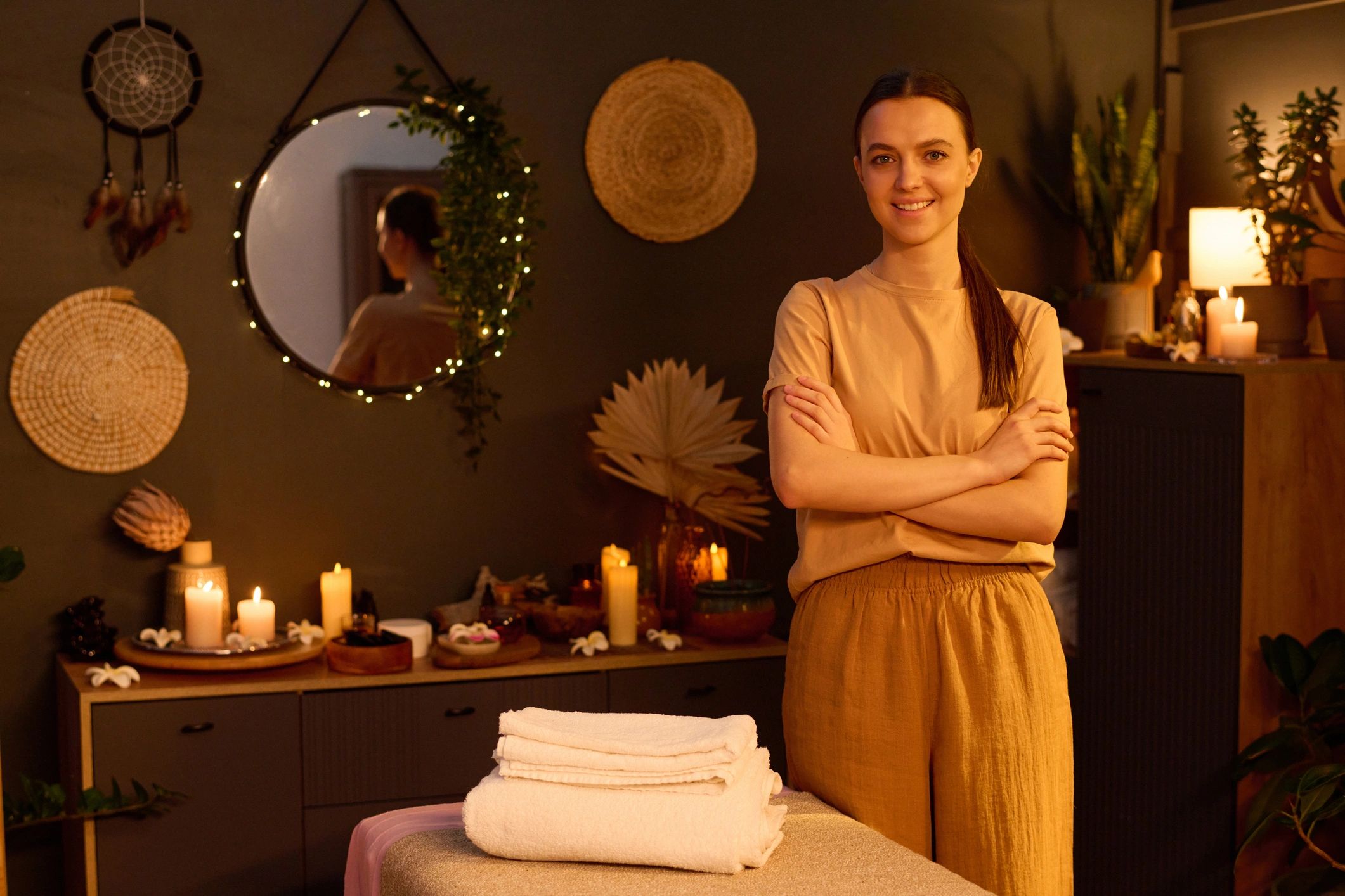Massage therapist standing beside a prepared massage table