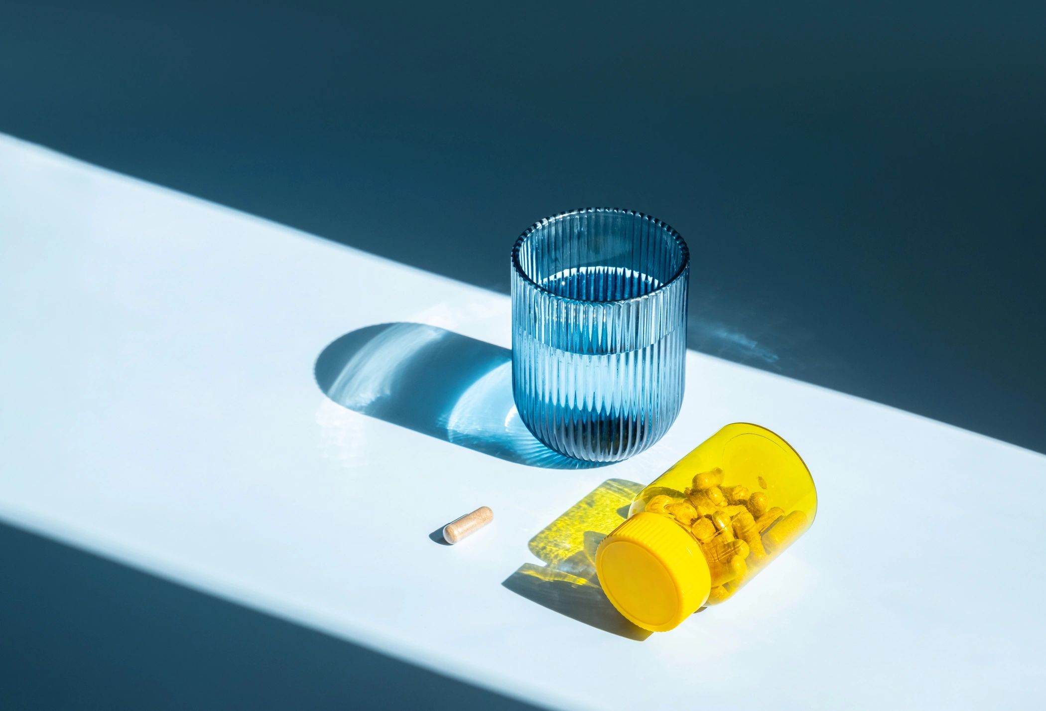 Vitamin bottle and capsules representing recovery support products