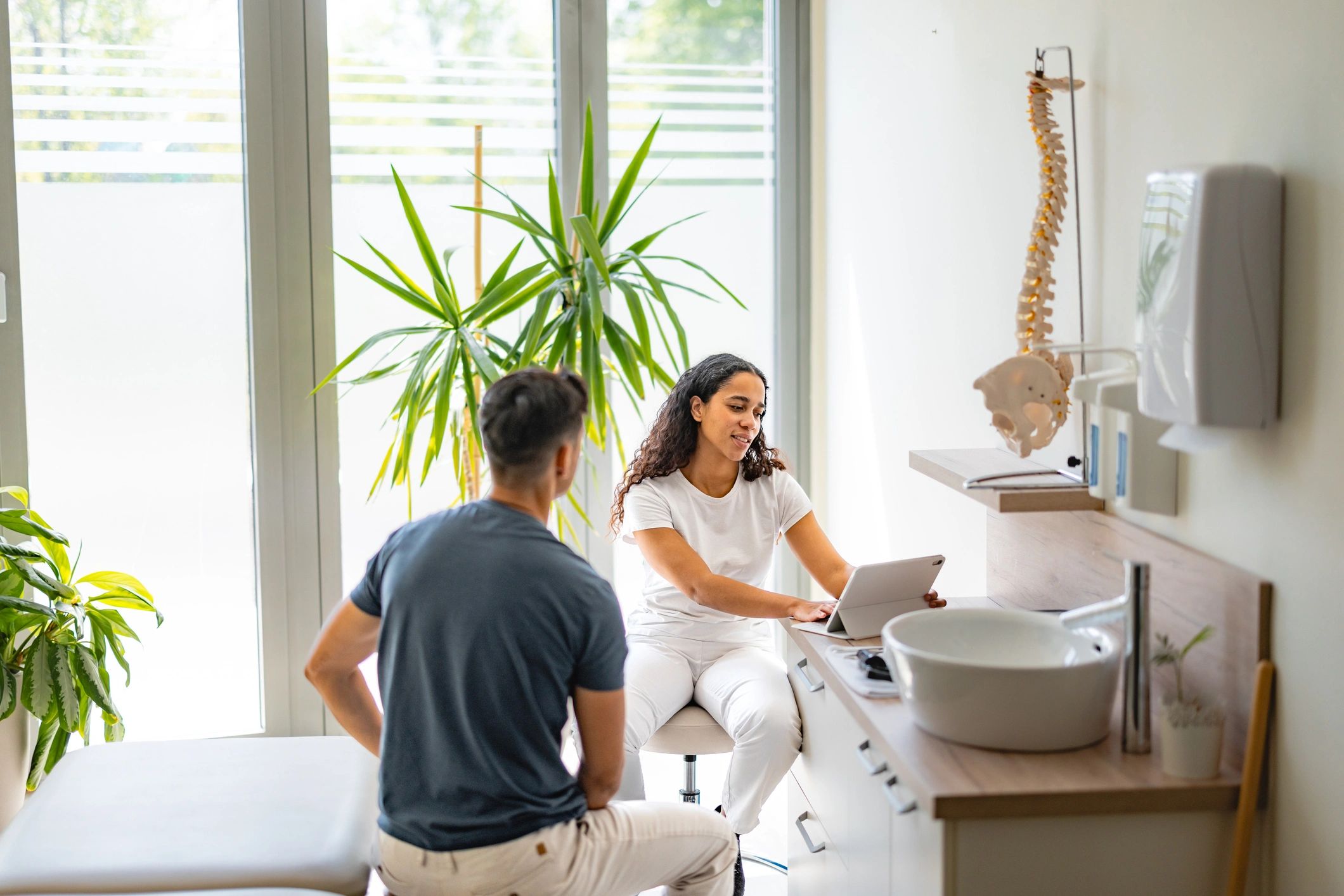 Practitioner reviewing a treatment plan with a patient in a bright clinic